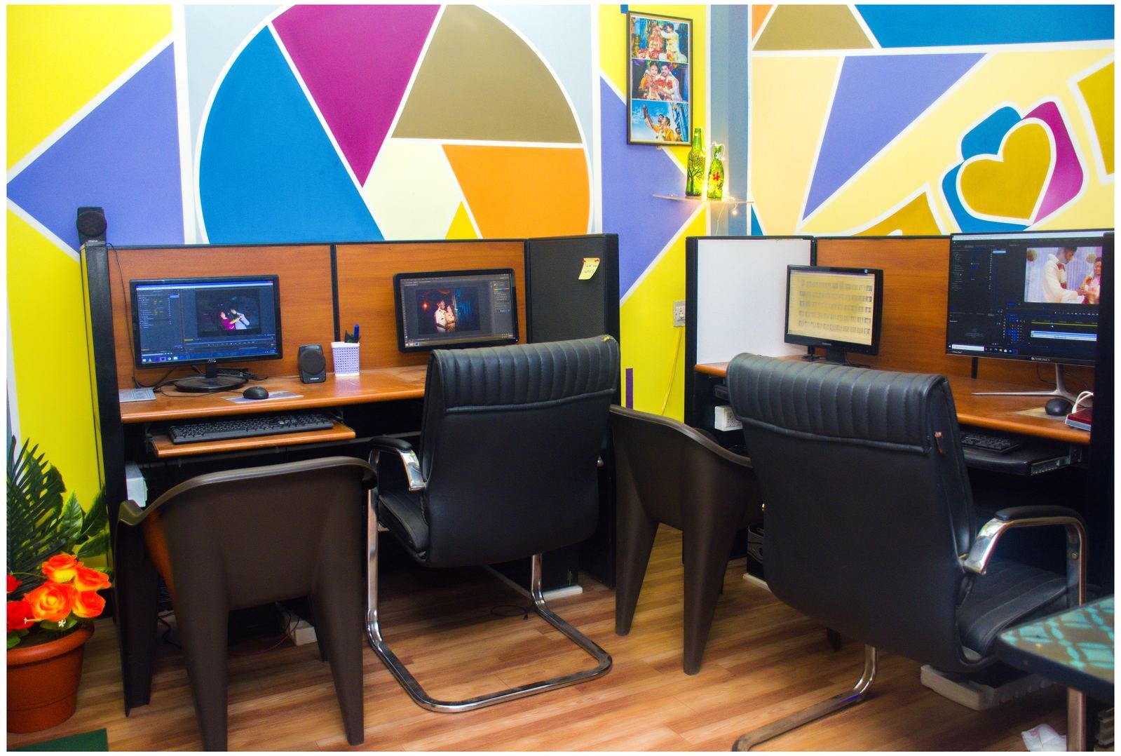Editing suite with dual-monitor workstations and colourful geometric wall art
