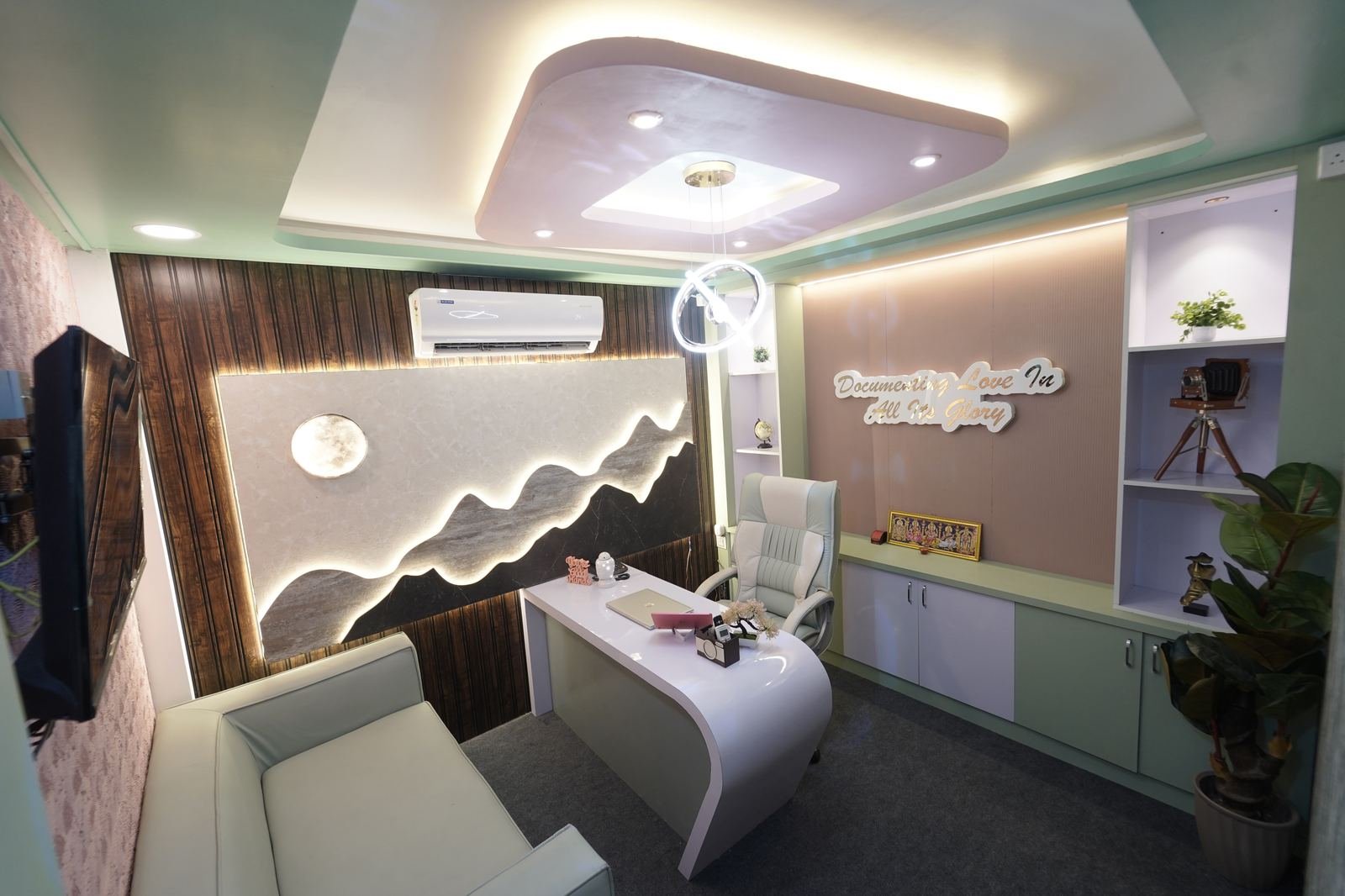 Bright reception area with a grey and yellow sofa and TV display
